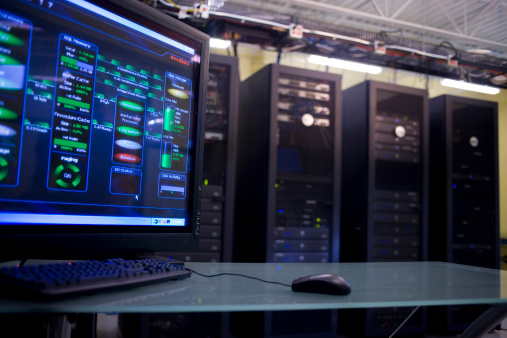 Monitoring-Bildschirm vor Serverracks im Rechenzentrum