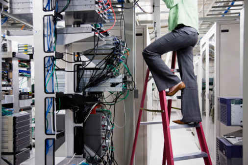 Techniker arbeitet an der Verkabelung eines Serverracks